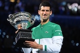 Tennis player smiling with the Australian Open trophy after winning the tournament