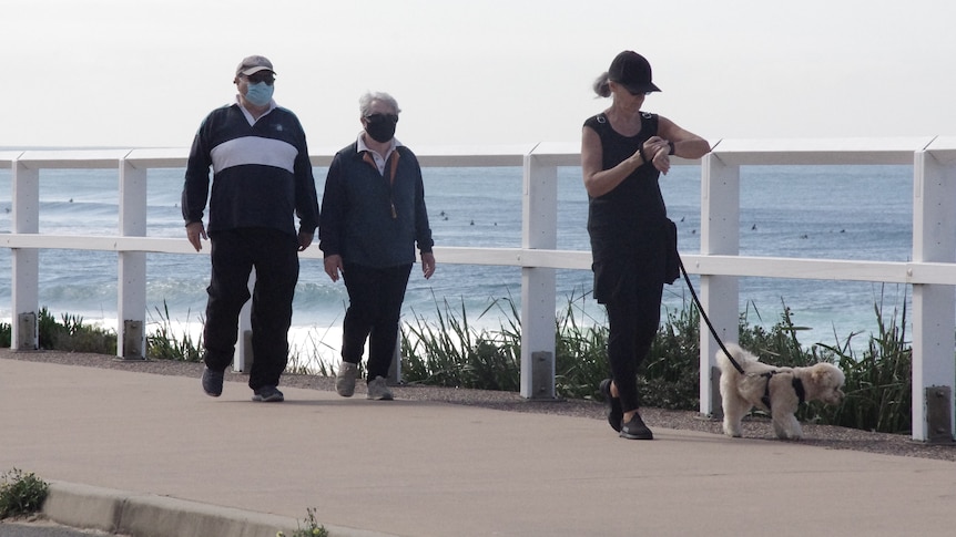 Two elderly people out for a morning stroll at Merewether beach.