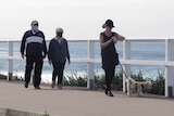 Two elderly people out for a morning stroll at Merewether beach.