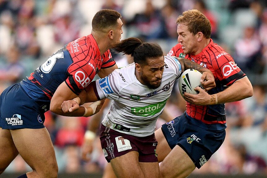 Manly's Jorge Taufua is tackled by the Roosters' Ryan Matterson, (L) and Mitchell Aubusson.