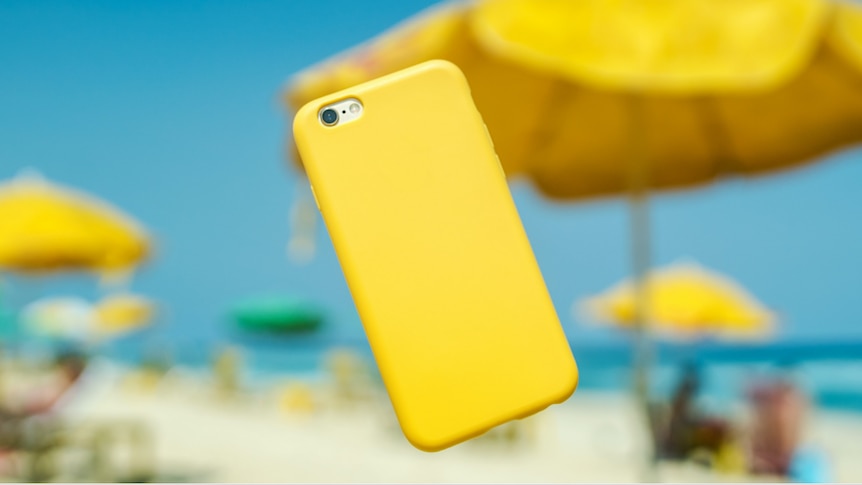 a yellow phone in mid air at the beach