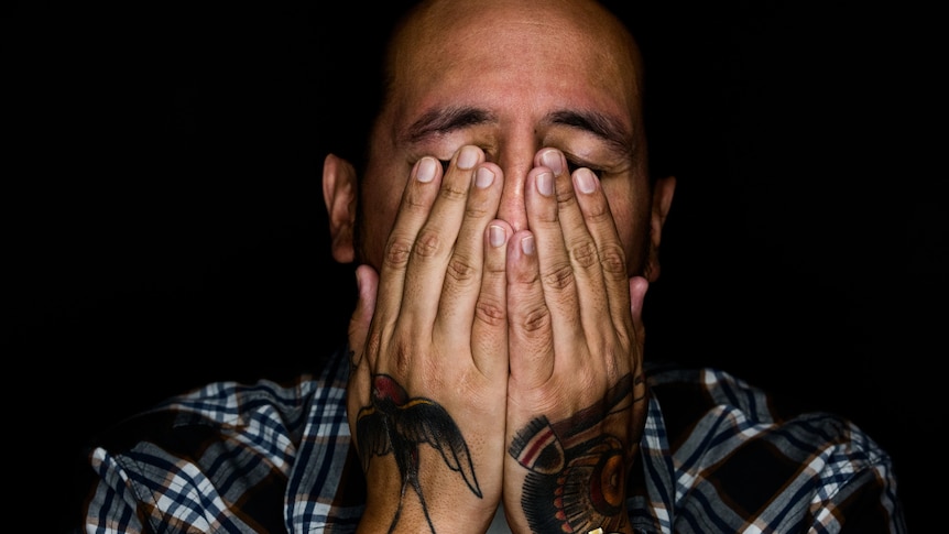 Man holds his head in his hands.