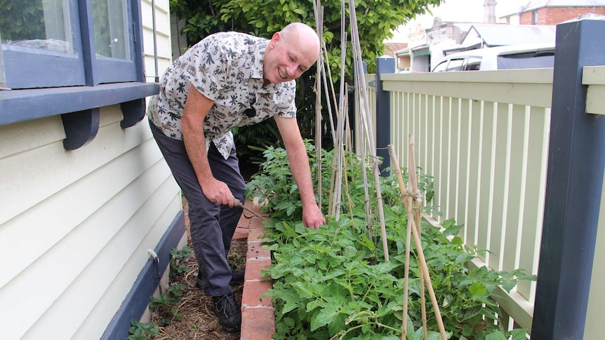 Melbourne University Professor Chris Walsh shows a garden bed at his Richmond home.