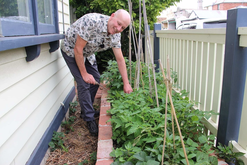 Melbourne University Professor Chris Walsh shows a garden bed at his Richmond home.