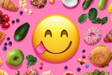 A graphic image shows an emoji face licking its lips surrounded by different foods including fruits, vegetables, chips, burgers