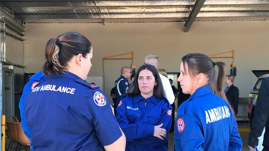 The head of NSW ambulance volunteers speaking to two new recruits at Coolamon Ambulance Station in their uniforms