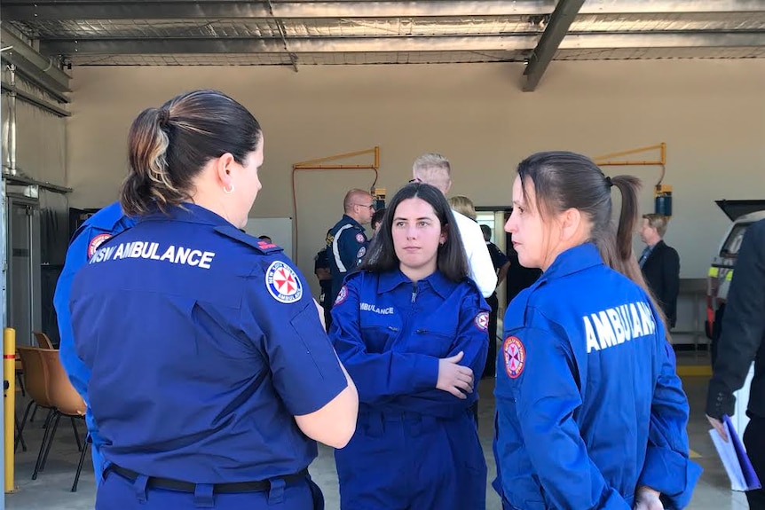 The head of NSW ambulance volunteers speaking to two new recruits at Coolamon Ambulance Station in their uniforms