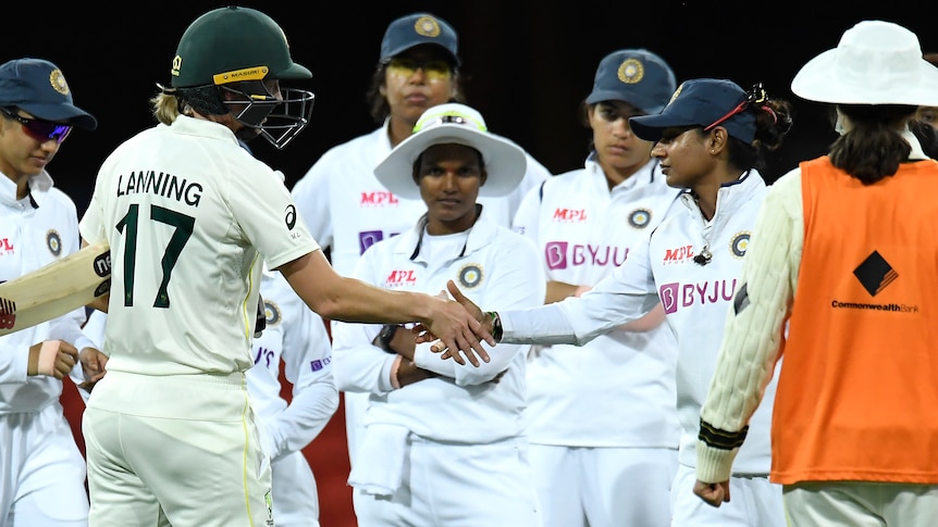 Meg Lanning, still in batting gear, shakes hands with Mithali Raj as the Indian team looks on