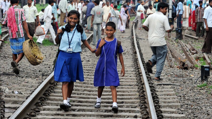 Indian school girls walk on the tracks