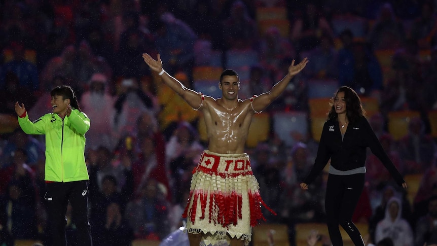 Tonga's flag bearer arrives at the Olympics closing ceremony.