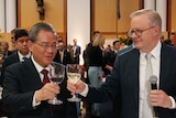 Li Qiang and Anthony Albanese toast two glasses of wine during a dinner