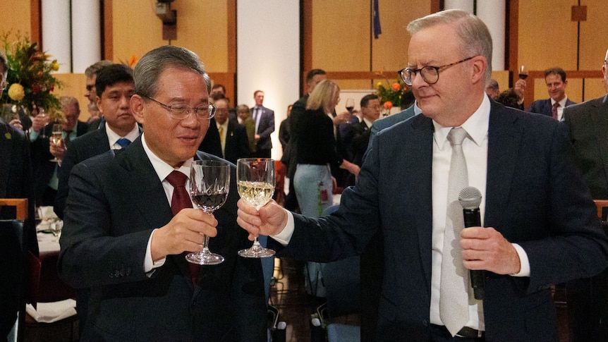 Li Qiang and Anthony Albanese toast two glasses of wine during a dinner