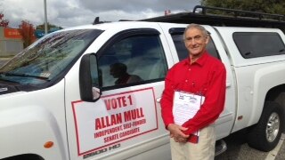 Allan Mull standing next to his vehicle with election signage