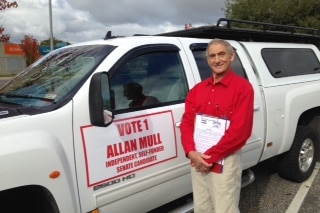 Allan Mull standing next to his vehicle with election signage