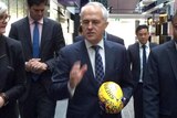 Prime Minister Malcolm Turnbull holds a Sherrin football while visiting the AFL Indigenous Advisory Council.