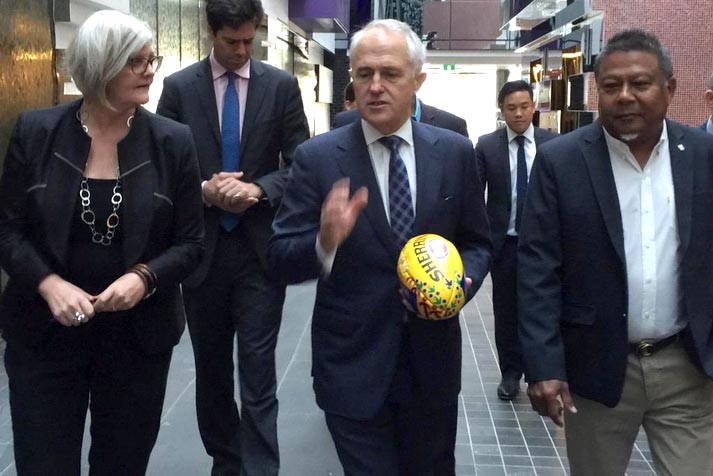 Prime Minister Malcolm Turnbull holds a Sherrin football while visiting the AFL Indigenous Advisory Council.