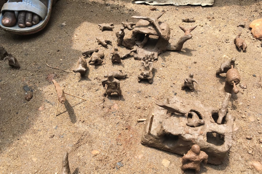 Army men, a helicopter, and a tank, made out of clay by South Sudanese children.