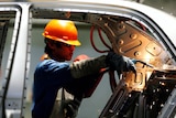 A Chinese labourer works on an assembly line