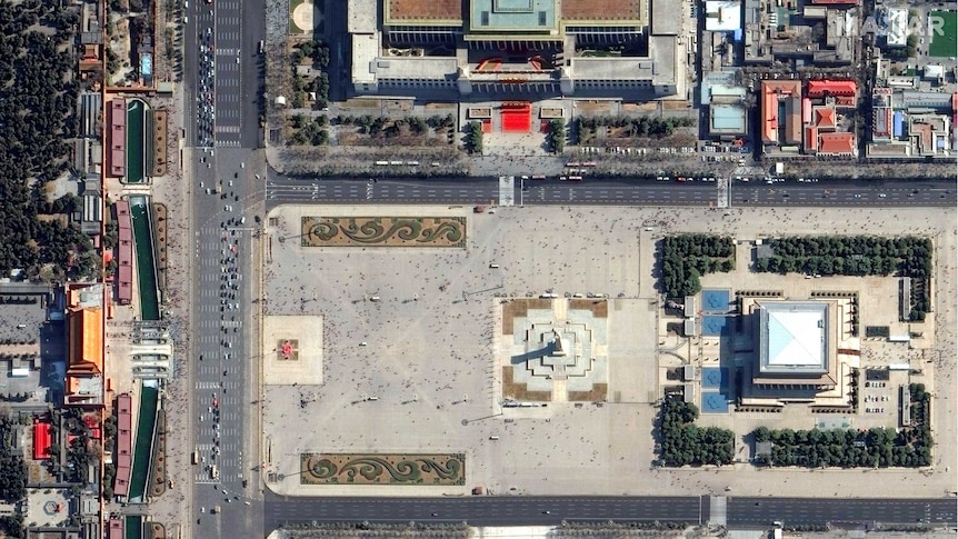 Satellite imagery shows a busy city square, dotted with hundreds of people.