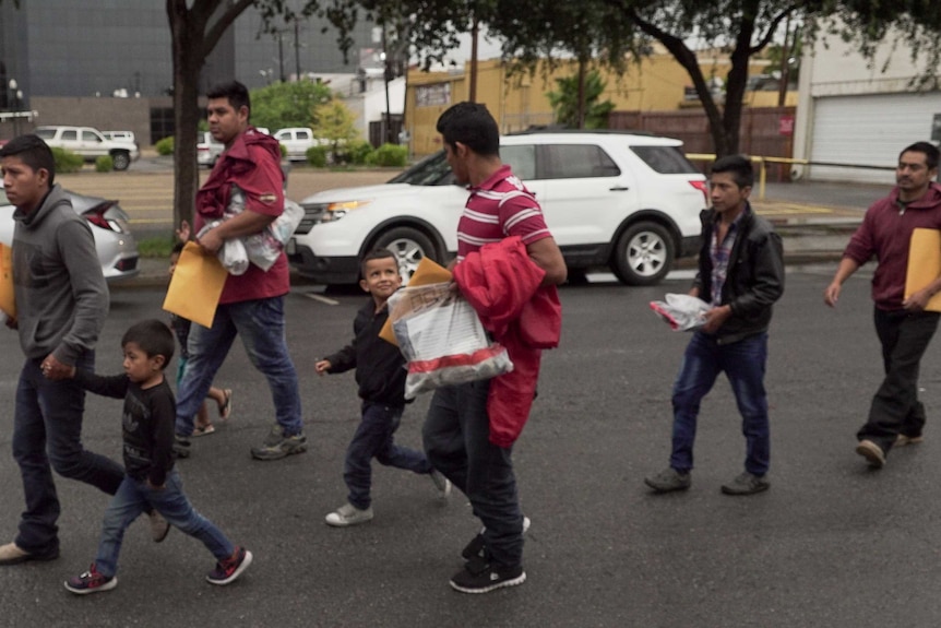 Families walk along a street in McAllen, Texas.