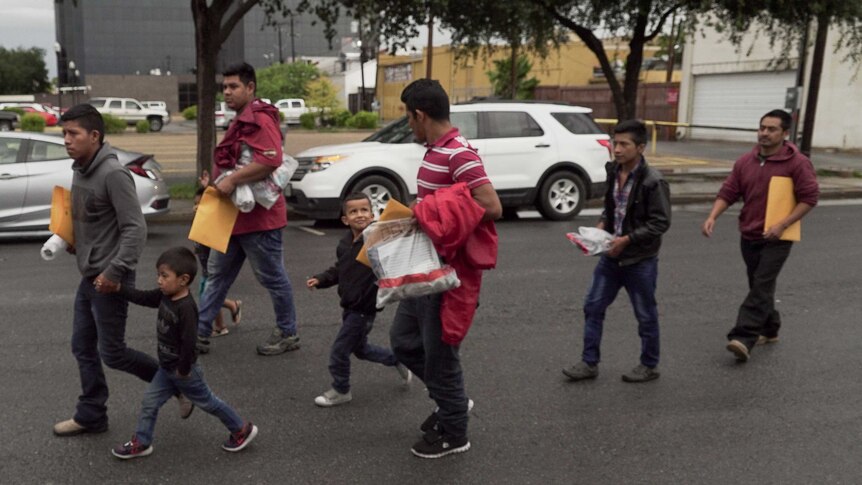 Families walk along a street in McAllen, Texas.