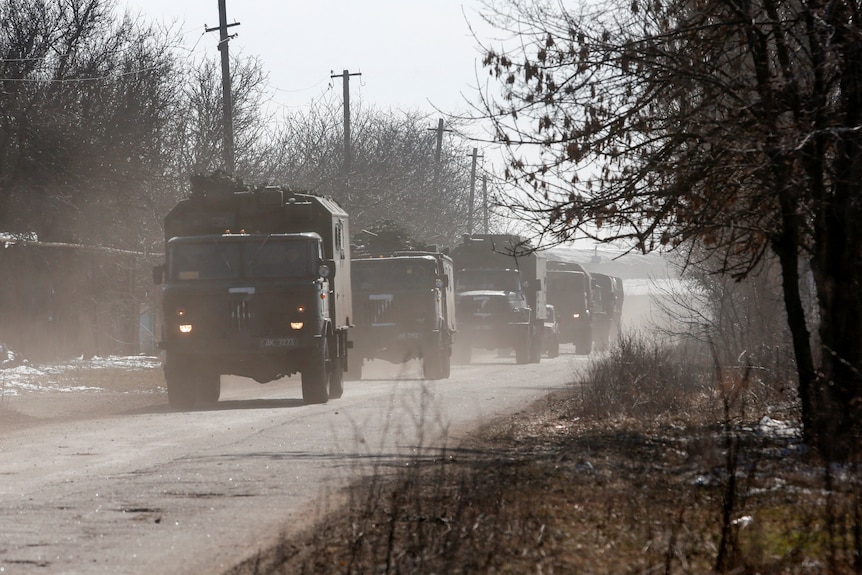 Russian military trucks spraypainted with the notorious 'Z" symbol roll into a town in Donetsk, March 12, 2022.