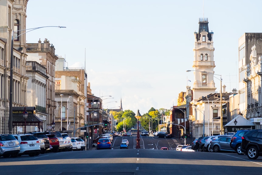 A busy street in Ballarat with old buildings on either side and cars on the street.