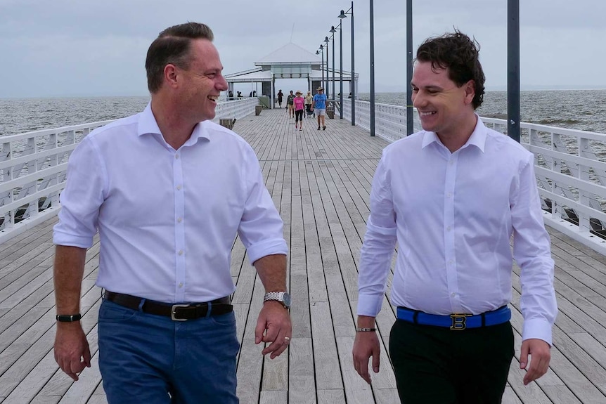 Two men walking along a pier.