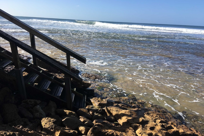 Tide lapping the bottom of steps at cliffs on Victoria's Surf Coast
