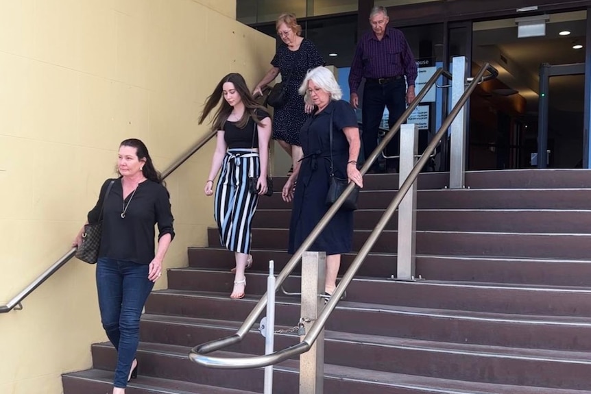 Five people descend the steps of a courthouse