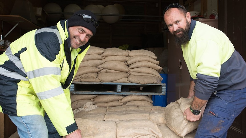 Council workers prepare sandbags for collection