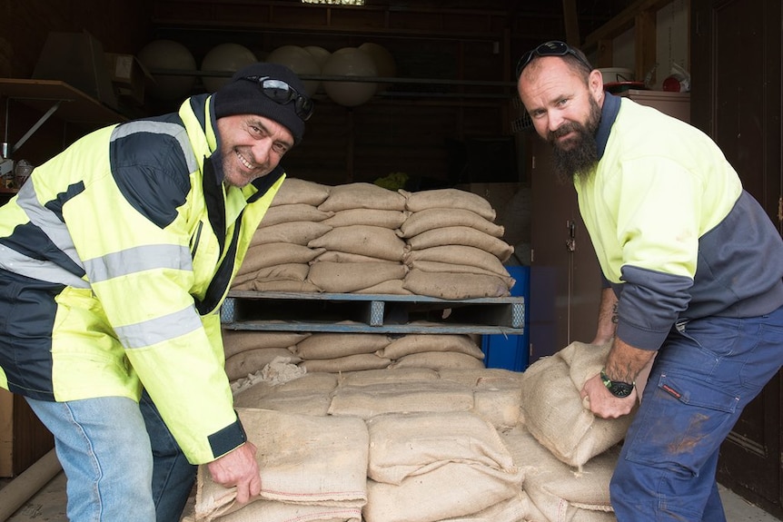 Council workers prepare sandbags for collection