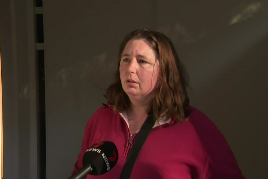 A woman with a 7 News microphone in front of her face.