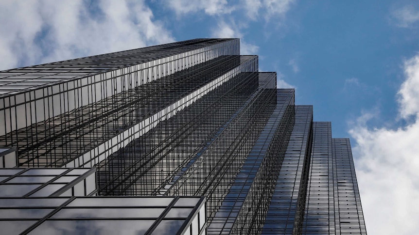 Trump Tower on 5th Avenue is seen in New York City, looking up to the sky. It's a diagonal row of square towers joined together.