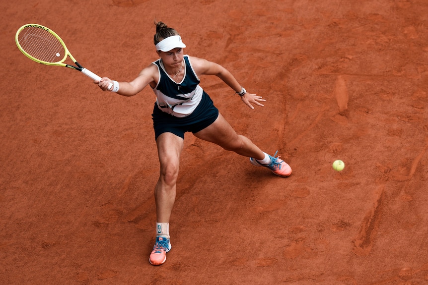Barbora Krejsikova scivola nel fango per colpire un dritto durante la finale del Roland Garros
