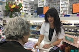 Sydney pharmacist Caroline Diamantis serves an elderly customer.