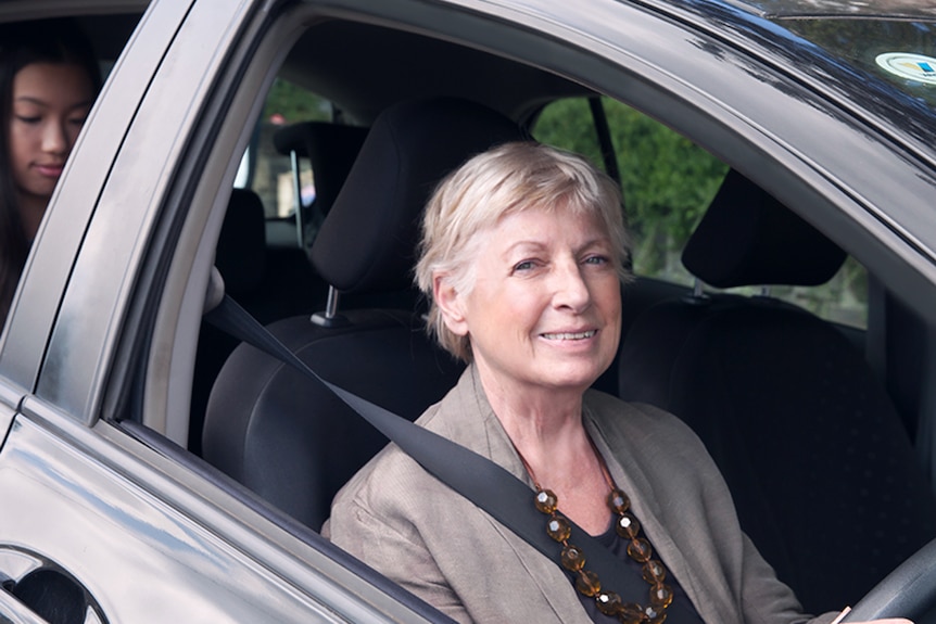 A woman driving a passenger.