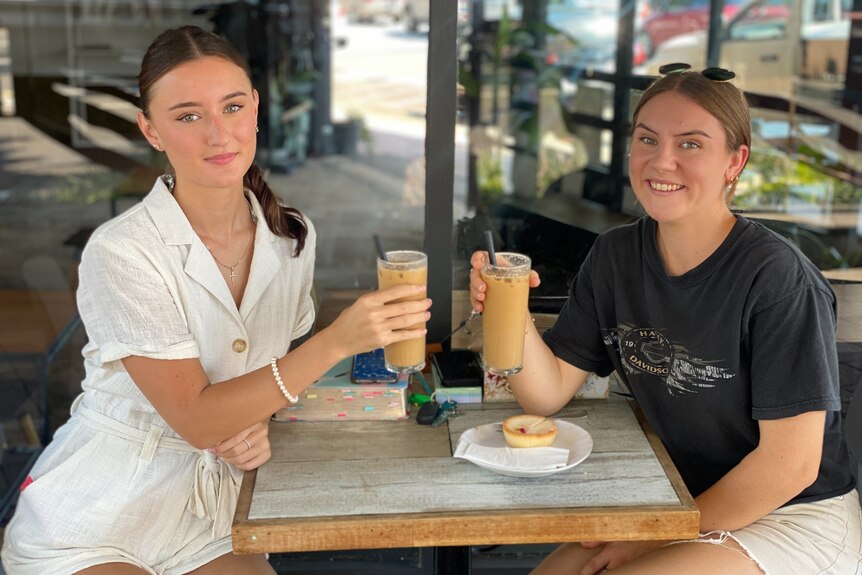 Two girls sip ice coffees 
