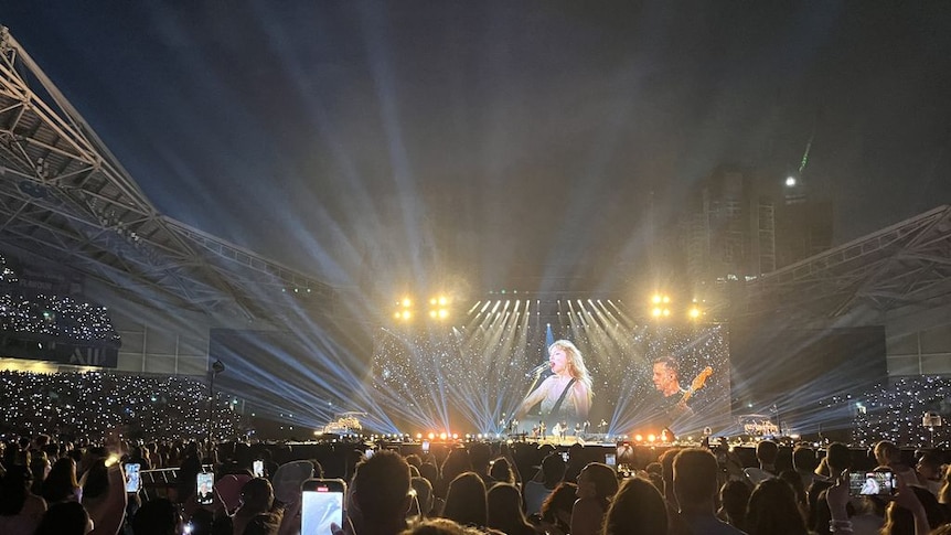 Thousands of people hold up phones as they watch Taylor Swift perform at Stadium Australia