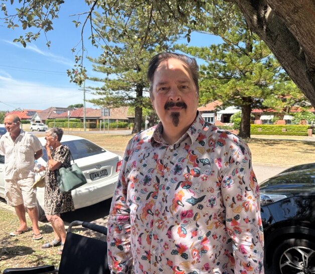 El hombre se encuentra debajo del árbol.
