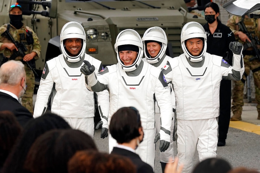 Astronauts, Victor Glover, Michael Hopkins, Shannon Walker, and Japanese astronaut Soichi Noguch waving to family.