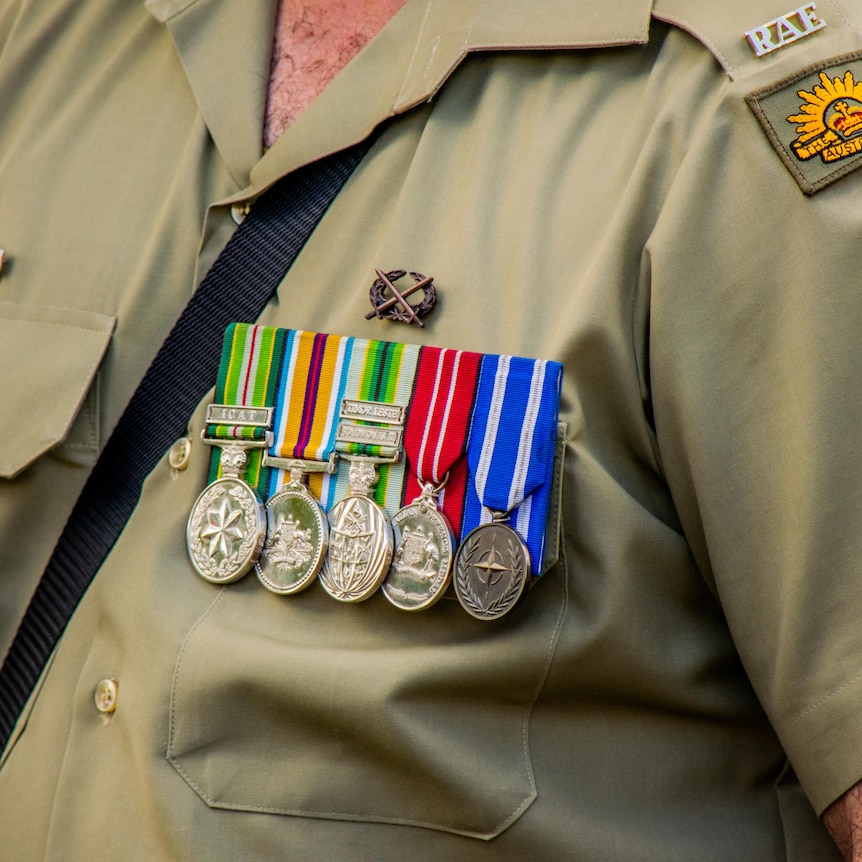A close up of the medals on a veteran. We can't see their face.