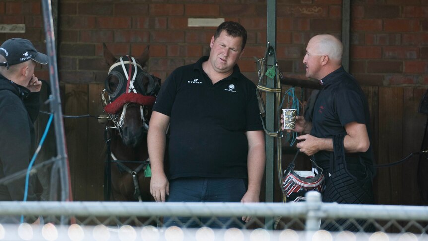 Ben Yole talks to someone at a horse stables.