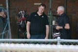 Ben Yole talks to someone at a horse stables.