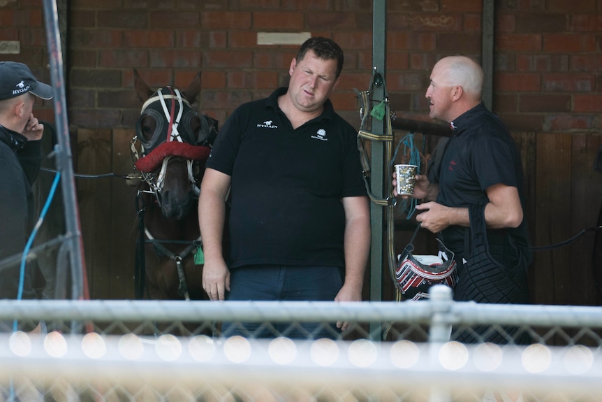 Ben Yole talks to someone at a horse stables.