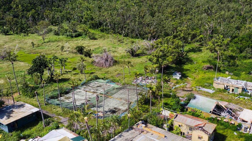 Aerial photo of damaged tennis courts and buildings at South Molle Island resort.
