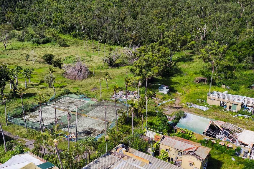 Aerial photo of damaged tennis courts and buildings at South Molle Island resort.