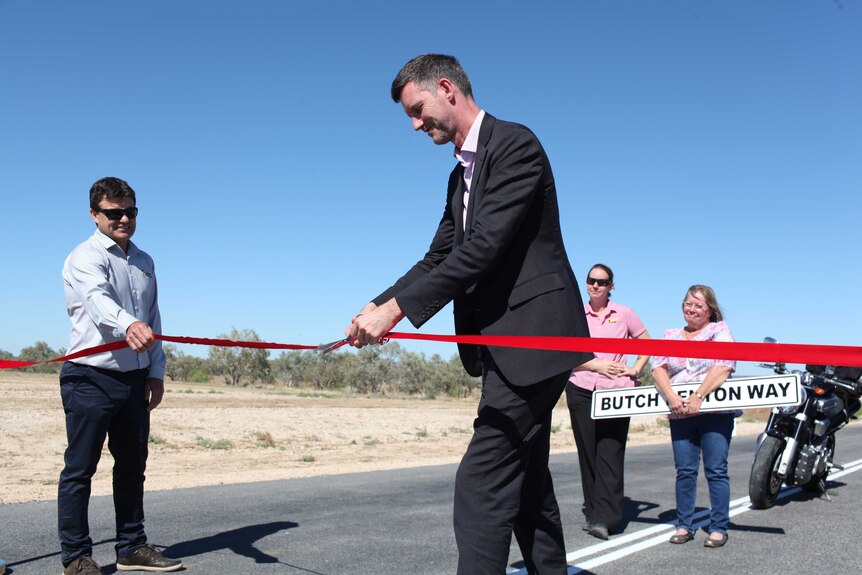 Minister for Transport and Main Roads Mark Bailey cutting the ribbon to open Butch Lenton Way in Western Queensland