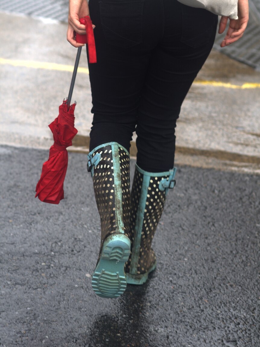 A woman walks through the CBD in Brisbane during heavy rain on January 25, 2012.