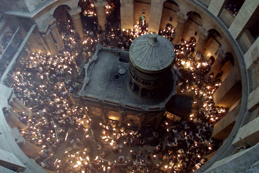 Overhead view of the tomb of Jesus inside the Church of the Holy Sepulchre filled with people performing a religious ceremony
